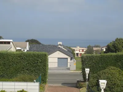 a house with a gate and hedges in a neighborhood at Casa Del Mar in Hermanus
