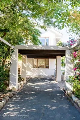 a walkway leading to a white house with a building at Cobie Apartment in Stellenbosch