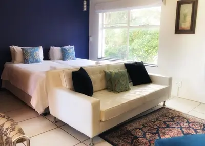 a living room with a couch and a bed at BlackHorse Accommodation in Stellenbosch