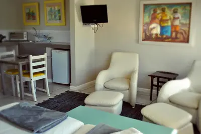 a living room with a table and chairs and a kitchen at BlackHorse Accommodation in Stellenbosch