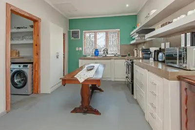 a large kitchen with a wooden table in it at The Koppie - Accommodation in Hermanus