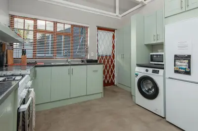 a kitchen with a washing machine and a washer at The Koppie - Accommodation in Hermanus