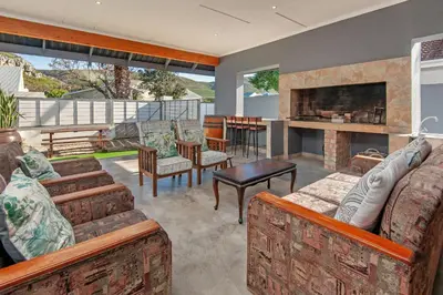 a living room with furniture and a fireplace at The Koppie - Accommodation in Hermanus