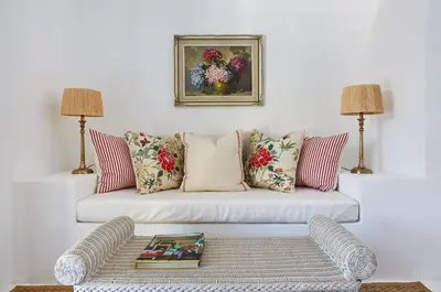 a living room with a white couch with pillows at La Cotte Forest Cottages in Franschhoek