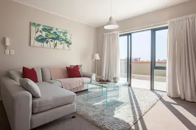 a living room with a couch and a glass table at Manhattan Towers 507 by CTHA in Cape Town