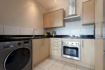 a kitchen with a washer and a dishwasher at Manhattan Towers 507 by CTHA in Cape Town