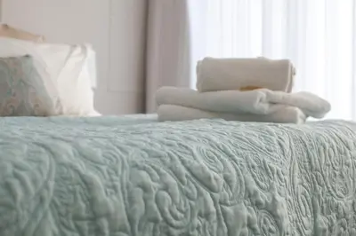 a bed with a pile of towels on top of it at Manhattan Towers 507 by CTHA in Cape Town