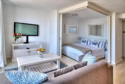 a hotel room with a bed and a couch at Horizon Bay 1404 by HMH in Bloubergstrand