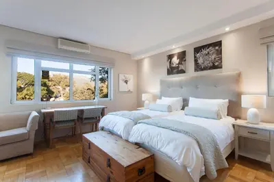 a bedroom with two beds and a desk and a window at 109 on Dorp in Stellenbosch