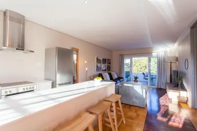 a kitchen and living room with a counter and chairs at 109 on Dorp in Stellenbosch