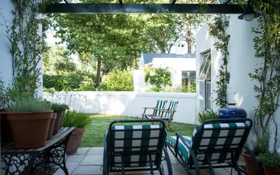 an outdoor patio with chairs and a table at Vredenhof Farm Cottage in Elgin