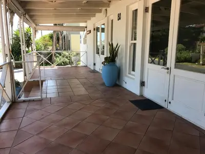 a screened porch with a tile floor and a vase at Leisure By The Sea in Kleinmond