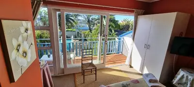 a room with a balcony with a sliding glass door at Blue Mountain Guest House in Bloubergstrand