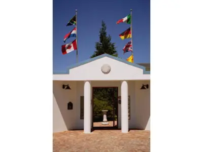 a group of flags flying in front of a building at Blue Mountain Guest House in Bloubergstrand