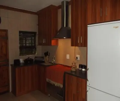 a kitchen with wooden cabinets and a refrigerator at Overmeer in Worcester