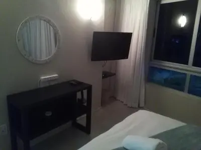a bedroom with a bed and a tv and a mirror at Sunset 786 Holiday Accommodation Unit-207 in Strand