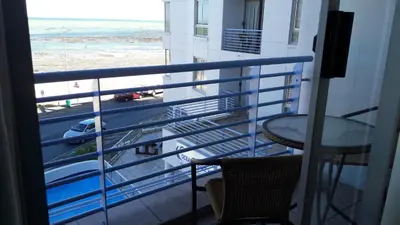a balcony with a table and a view of the beach at Sunset 786 Holiday Accommodation Unit-207 in Strand
