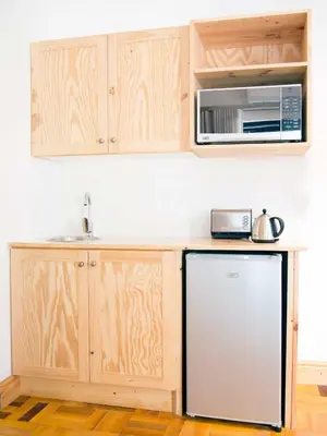 a kitchen with a refrigerator and a microwave at 7 Ackermann Place Guest House in Stellenbosch