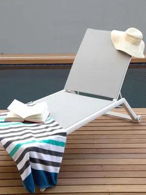 a chair with a book and a hat on a deck at 7 Ackermann Place Guest House in Stellenbosch
