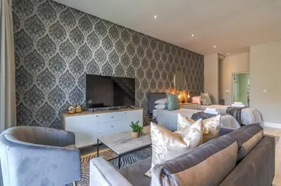 a living room with a couch and a tv at Crossfire @ Home in Somerset West