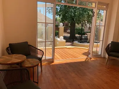 a living room with a door open to a patio at De Haas Luxury Living at Villa Grande in Stellenbosch