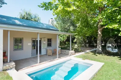 a house with a swimming pool in the yard at La Chataigne Wines & Guest Cottages in Franschhoek