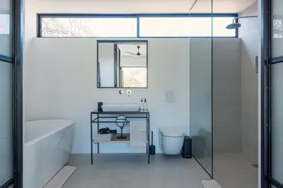 a bathroom with a tub and a sink and a mirror at La Chataigne Wines & Guest Cottages in Franschhoek