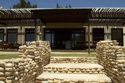 a stone wall in front of a building at The Riverstone House in Romansrivier
