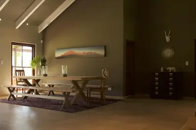 a dining room with a wooden table and bench at The Riverstone House in Romansrivier