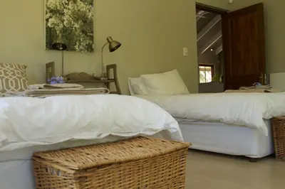 a bedroom with two beds with white sheets and a mirror at The Riverstone House in Romansrivier