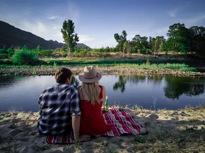 a man and a woman sitting next to a lake at The Riverstone House in Romansrivier