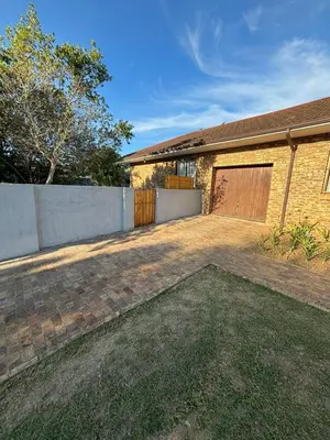 a brick house with a garage and a fence at Stellenhaus Guest Cottage in Stellenbosch