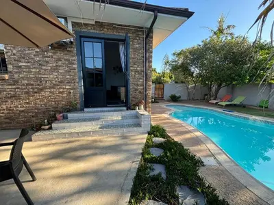 a house with a swimming pool in front of a house at Stellenhaus Guest Cottage in Stellenbosch