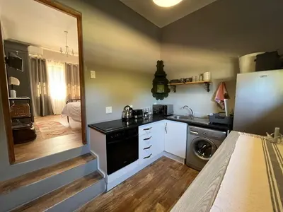 a small kitchen with a sink and a dishwasher at Stellenhaus Guest Cottage in Stellenbosch