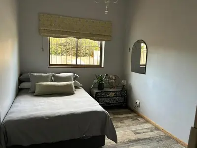 a bedroom with a large bed and a window at Stellenhaus Guest Cottage in Stellenbosch