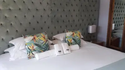 a white bed with two towels on top of it at Slaley Country House in Stellenbosch