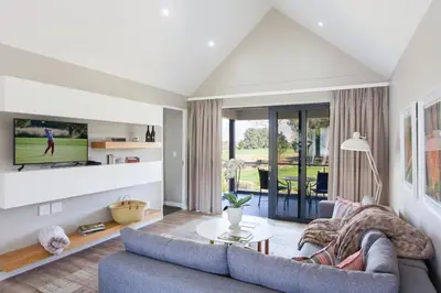 a living room with a couch and a tv at Pearl Valley Hotel in Franschhoek
