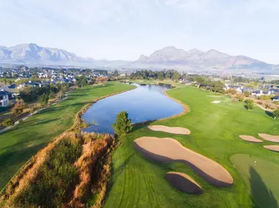 an aerial view of a golf course with a lake at Pearl Valley Hotel in Franschhoek