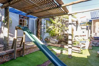 a playground with a slide in a yard at Strand Guesthouse in Strand