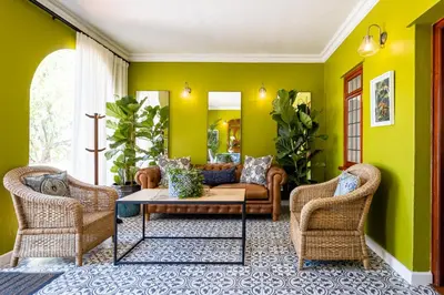 a living room with green walls and a couch and chairs at Laborie Estate in Paarl