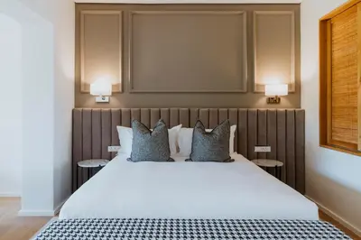 a bedroom with a large white bed with pillows at Laborie Estate in Paarl