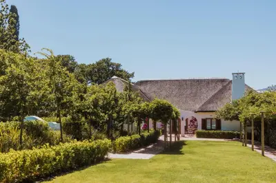 a house with a yard with trees and grass at Laborie Estate in Paarl