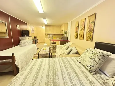 a living room with two beds and a couch at Marshrose Accommodation in Bellville