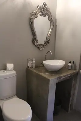 a bathroom with a sink and a toilet and a mirror at 35 on Basil in Caledon