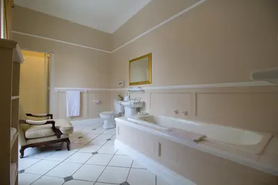 a bathroom with a tub and a toilet and a sink at Pontac Manor Hotel & Restaurant in Paarl