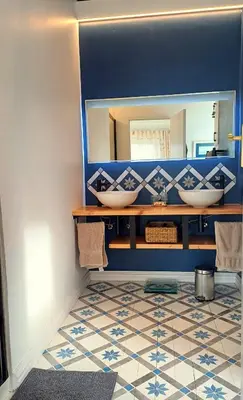 a bathroom with two sinks and a mirror at Charming Fisante house in Hermanus