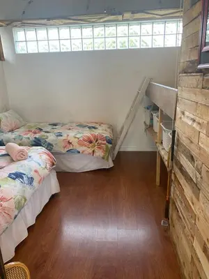 a bedroom with two beds and a wooden floor at Dancers' Cottages in Cape Town