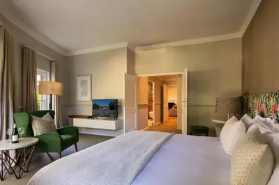 a hotel room with a bed and a television at Mont Rochelle Hotel and Vineyard in Franschhoek