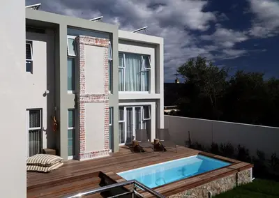 a house with a swimming pool on a deck at Cape Coral in Hermanus