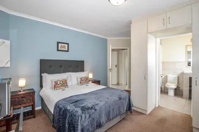 a bedroom with a large bed and a bathroom at Atlantic Breeze in Cape Town